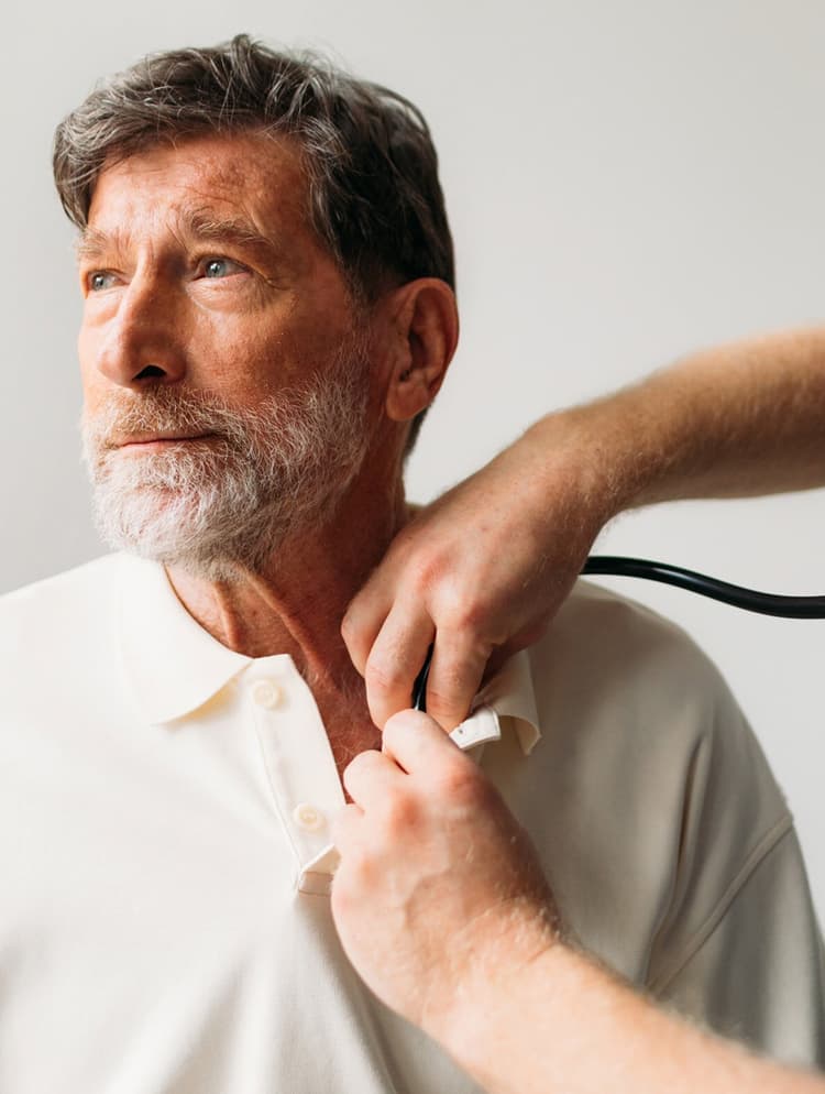 Médico em atendimento, auscultando um paciente